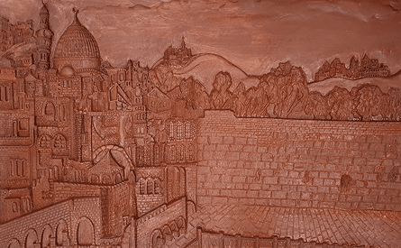 Close-up of a terracotta-toned relief of Jerusalem and the Western Wall
